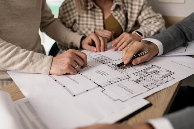 three people going over a blueprint