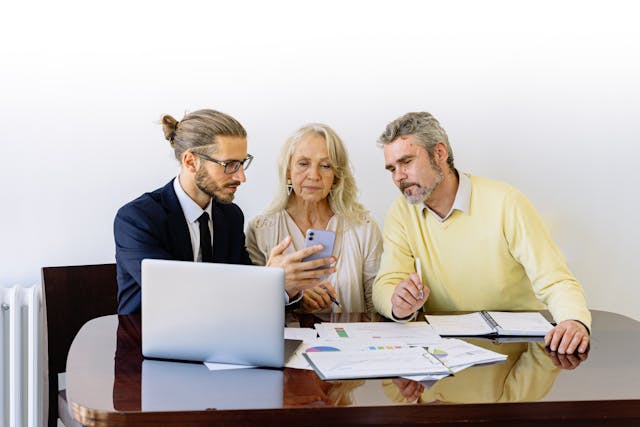three people looking over documents