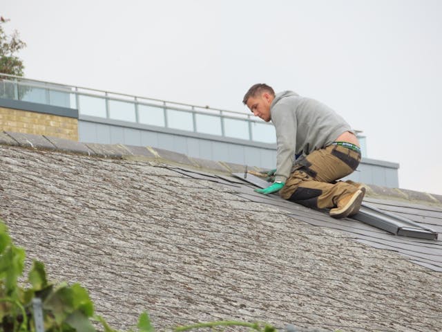 person fixing house roof